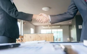 Business-handshake-in-office-setting–Public-Housing-UK