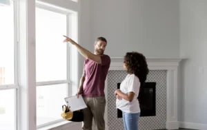 A-man-and-woman-talk-near-a-window-in-a-modern-home-during-a-Supported-Housing-inspection