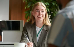 A-smiling-woman-in-a-professional-setting-discussing-Supported-Housing-solutions
