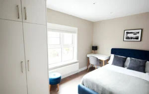 Modern-supported-living-accommodation-bedroom-with-bed-desk-and-wardrobe