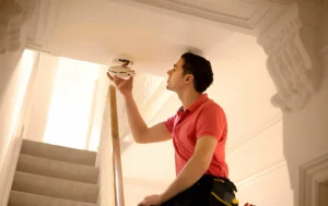A-person-installing-a-fire-alarm-aligning-with-the-fire-safety-to-ensure-safety-and-positivity