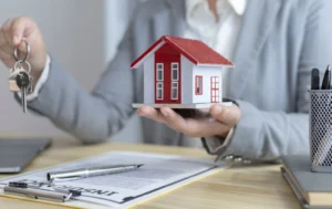 Business-person-holding-a-house-model-and-keys-for-Guaranteed-Rental-Income