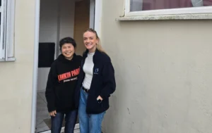 Client-and-housing-professional-smiling-together-outside-a-property-part-of-a-Supported-Housing-Solution