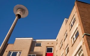 low-angle-view-of-residential-flats-with-red-door-and-street-lamp