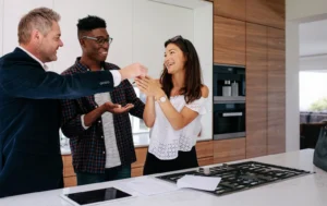 A-couple-receiving-house-keys-with-a-real-estate-agent-representing-Landlord-Guaranteed-Rent