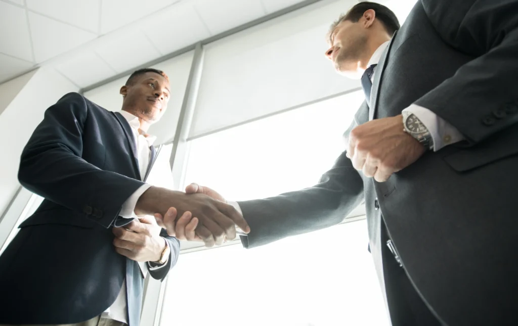 Overseas-investor-handshaking-with-partner-in-business-office