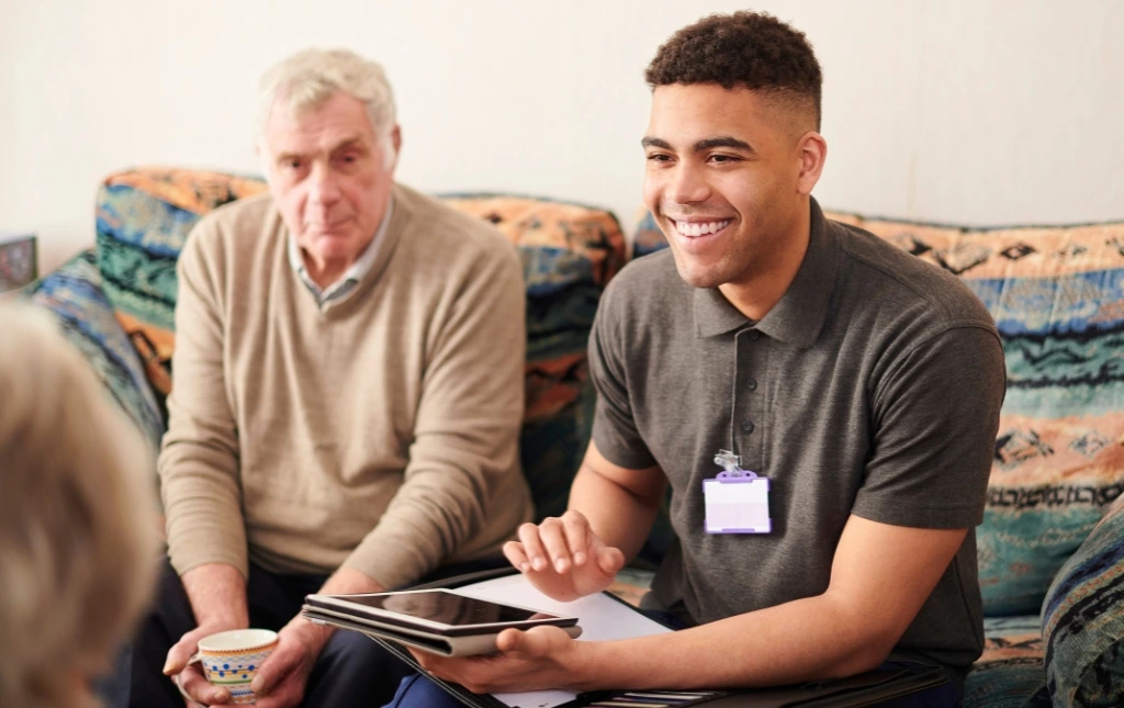 Smiling-care-worker-talking-with-elderly-man-making-a-meaningful-&-ethical-impact-with-our-guaranteed-rent-solutions