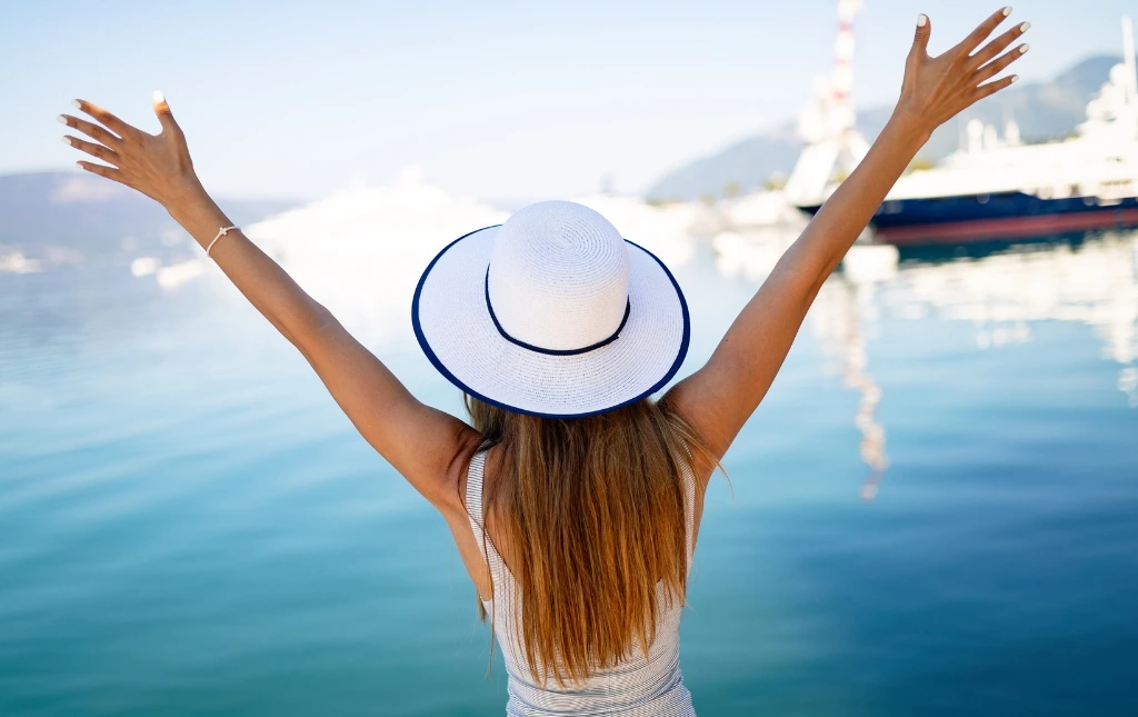 Woman-with-arms-raised-enjoying-a-peaceful-waterfront-viewmore-time-for-you-to-relax-with-our-guaranteed-rent-solutions
