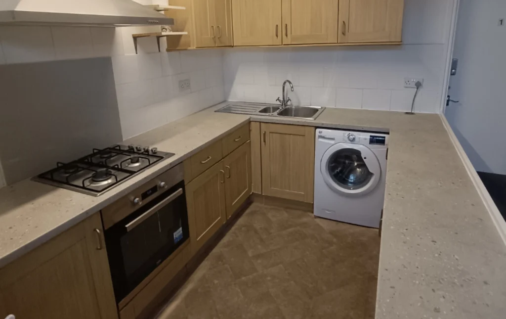 A-kitchen-with-a-washing-machine-oven-and-sink